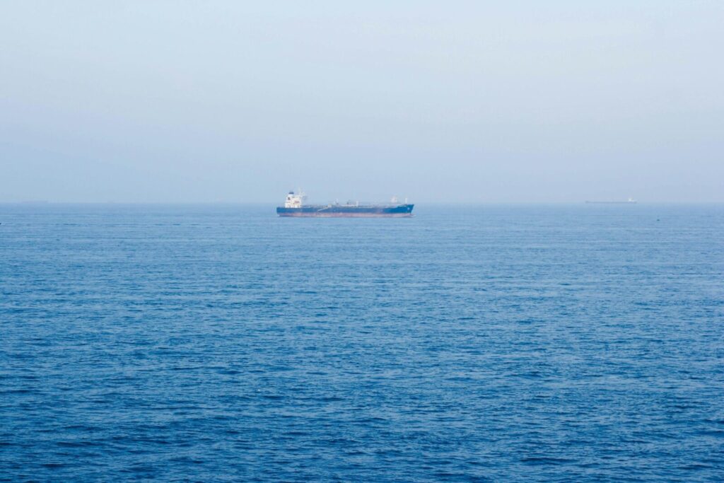 A large cargo ship sails on the tranquil ocean near Vũng Tàu, Vietnam, symbolizing global commerce.