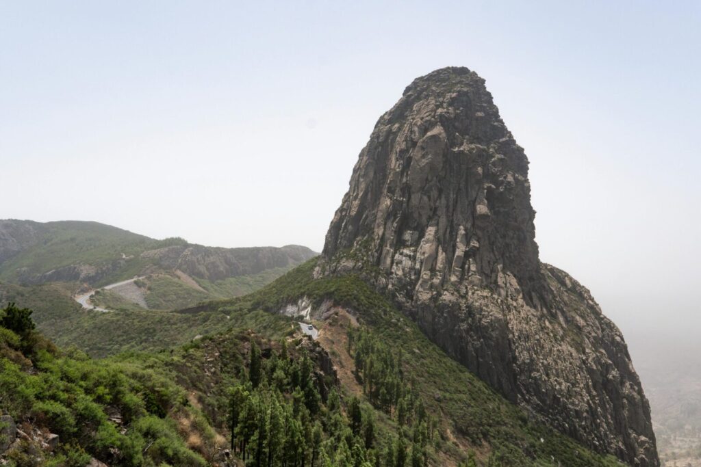 Discover the towering beauty of La Gomera's rock formations with lush green surroundings.