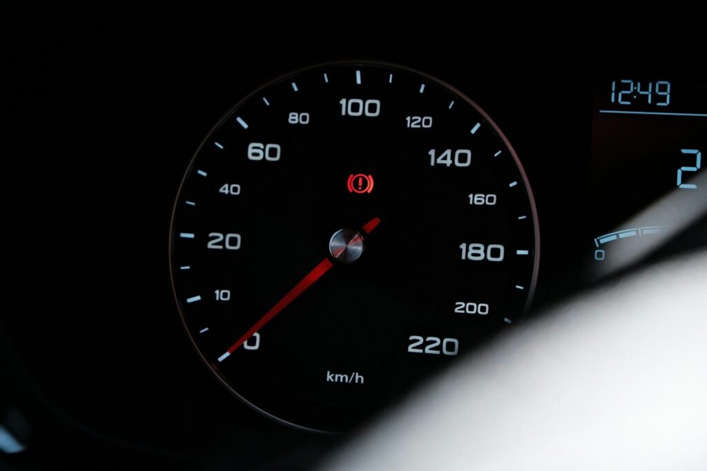 Detailed view of a car speedometer showing speed in km/h with a warning light