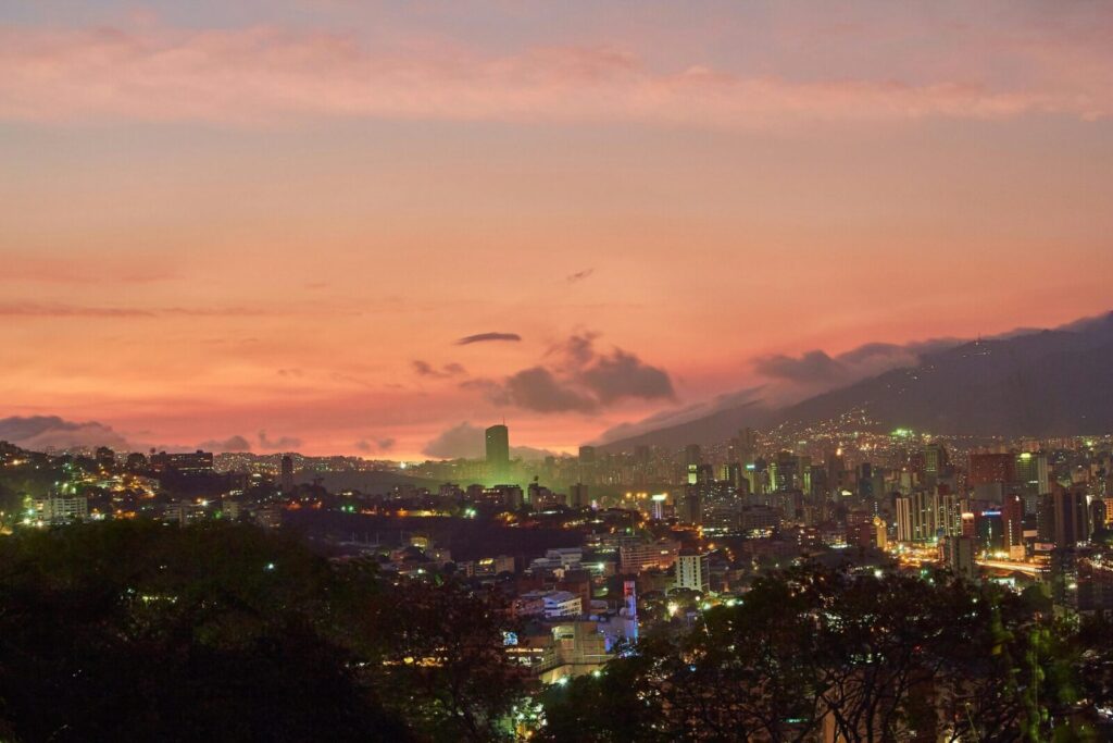 A breathtaking view of Caracas skyline at twilight with a vivid sunset backdrop.