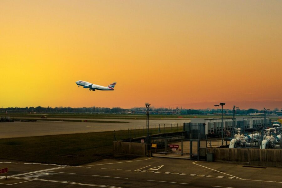 Airplane ascending during sunset at Heathrow Airport, capturing the vibrant sky.