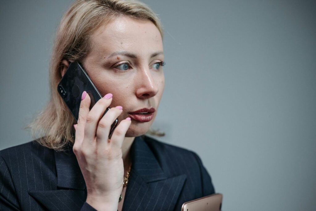 Focused businesswoman in corporate attire engaged in a phone call.