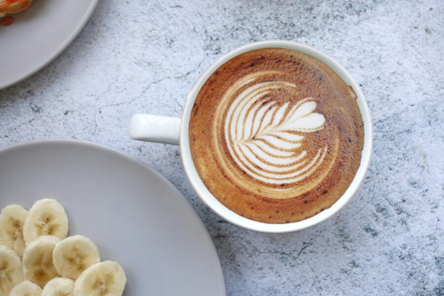 a cup of coffee with a design on the foam