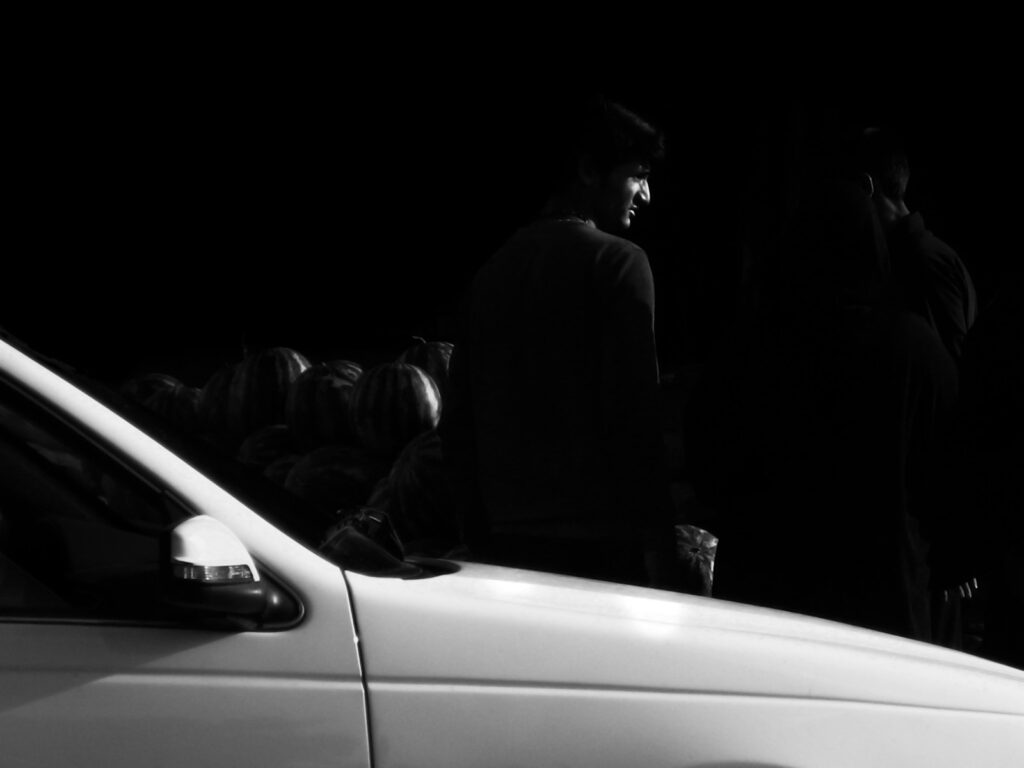 man standing beside white vehicle