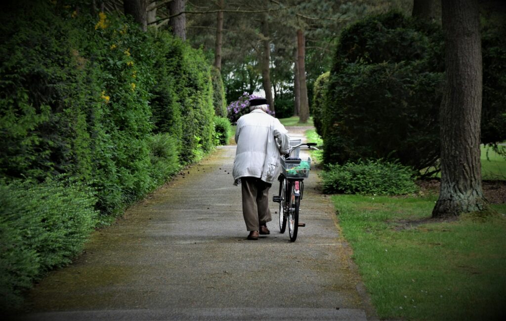 woman in white dress riding bicycle on gray concrete road during daytime