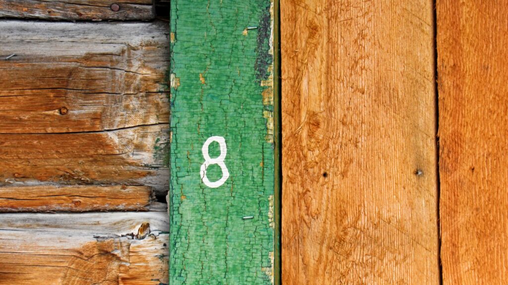 A close up of a number on a wooden wall