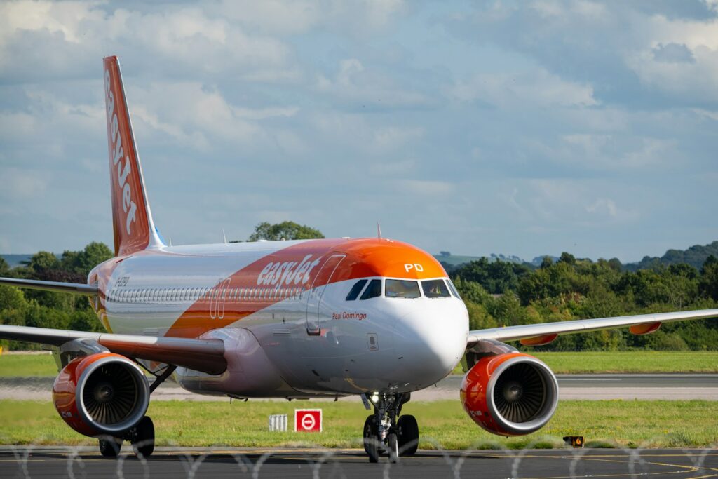 An orange and white airplane is on the runway